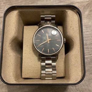 Women’s fossil watch. Silver band with black watch face. Gold/white hands.